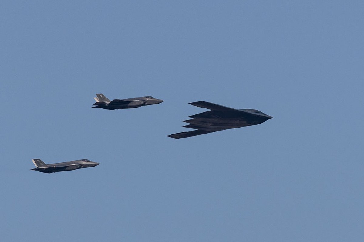 A U.S. Air Force B-2 Spirit stealth bomber, flanked by two F-22 Raptor fighter jets, flies over Washington, D.C., during Independence Day celebrations on July 4, 2025.