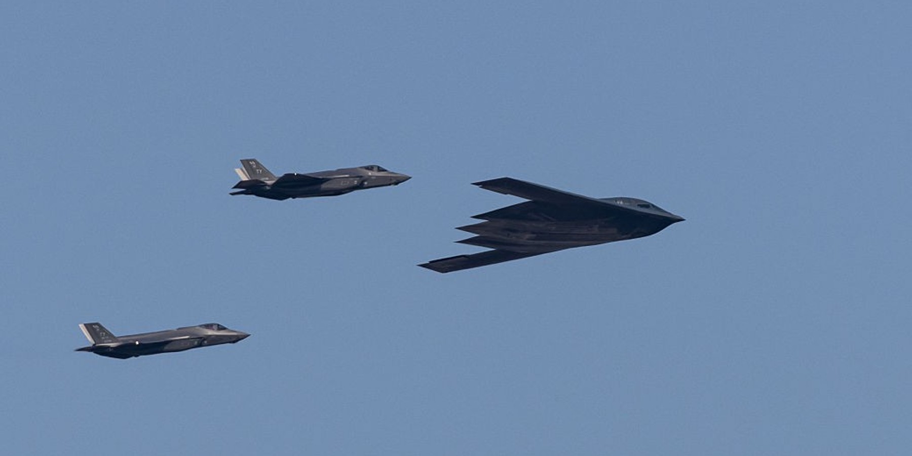 A U.S. Air Force B-2 Spirit stealth bomber, flanked by two F-22 Raptor fighter jets, flies over Washington, D.C., during Independence Day celebrations on July 4, 2025.