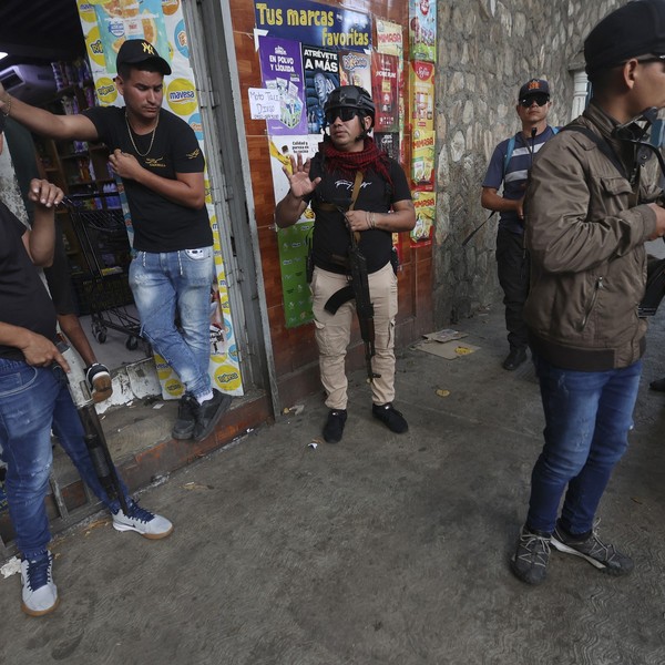 Armed supporters of ousted Venezuelan President Nicolas Maduro stand guard