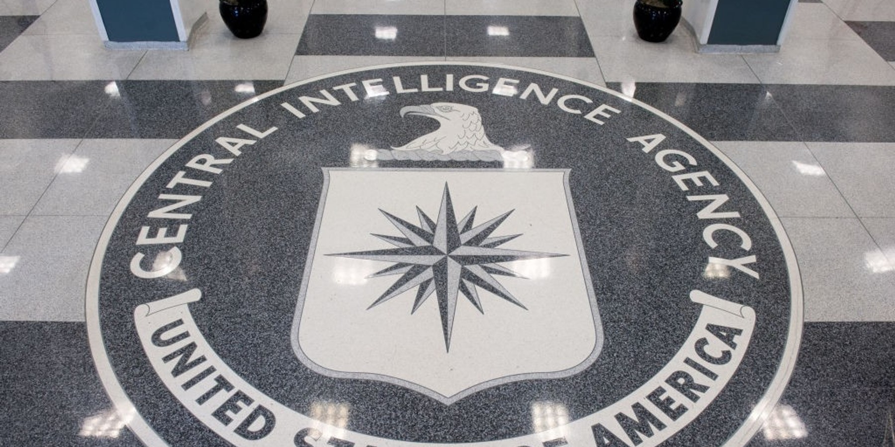 CIA emblem displayed on checkered floor in headquarters lobby.