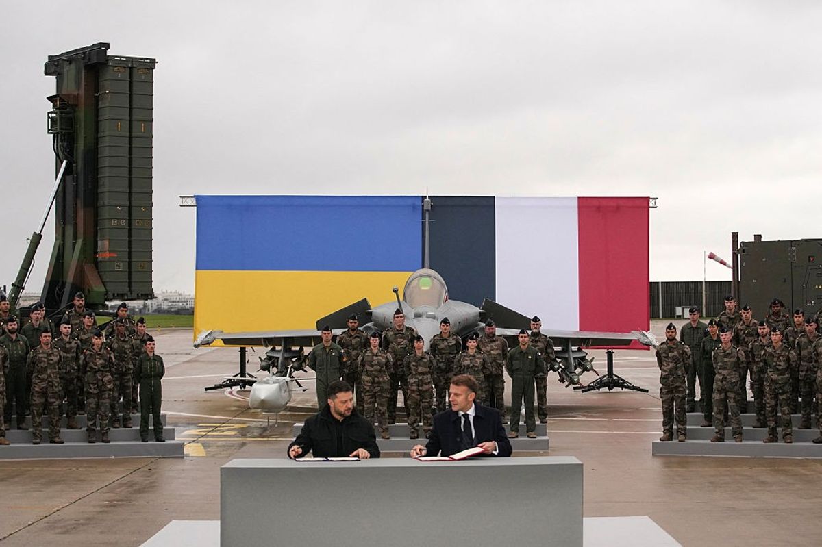 France's President Emmanuel Macron (R) and Ukraine's President Volodymyr Zelensky (L) sign an agreement at the Villacoublay air base, in Velizy-Villacoublay, near Paris on November 17, 2025.