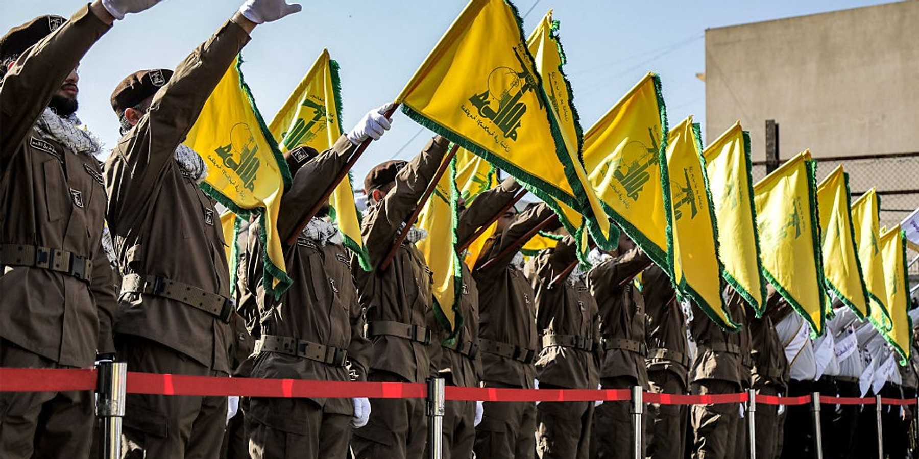 Hezbollah members salute and raise the group's yellow flags during the funeral of their fallen comrades Ismail Baz and Mohamad Hussein Shohury, who were killed in an Israeli strike on their vehicles, in Shehabiya in south Lebanon on April 17, 2024. (Photo by AFP) (Photo by -/AFP via Getty Images)