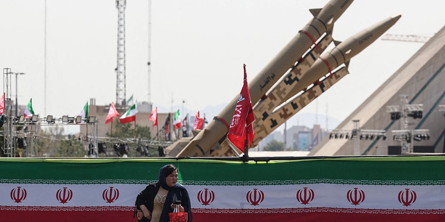 IRAN-US-ISRAEL-WAR A woman stands next to Iranian-made Zolfaghar missiles displayed at Azadi Square in Tehran on July 24, 2026. Iran's army said on July 24 it carried out drone strikes against several American military facilities and bases in Bahrain and Jordan in retaliation for the latest US attacks against the Islamic republic. (Photo by AFP via Getty Images) /