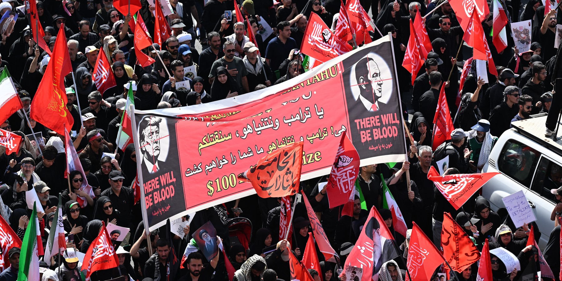 IRAN-US-ISRAEL-WAR-FUNERAL People hold a banner depicting US President Donald Trump and Israel's Prime Minister Benjamin Netanyahu displaying the words "There Will Be Blood" as they gather along a street for the funeral procession of Iran's slain Supreme Leader Ali Khamenei in Tehran July 6, 2026. The funeral procession for Iran's late supreme leader Ali Khamenei began in Tehran on July 6, state television reported, as authorities prepared for crowds that could rival those that turned out for his predecessor nearly four decades ago. (Photo by Wakil Kohsar / AFP via Getty Images)