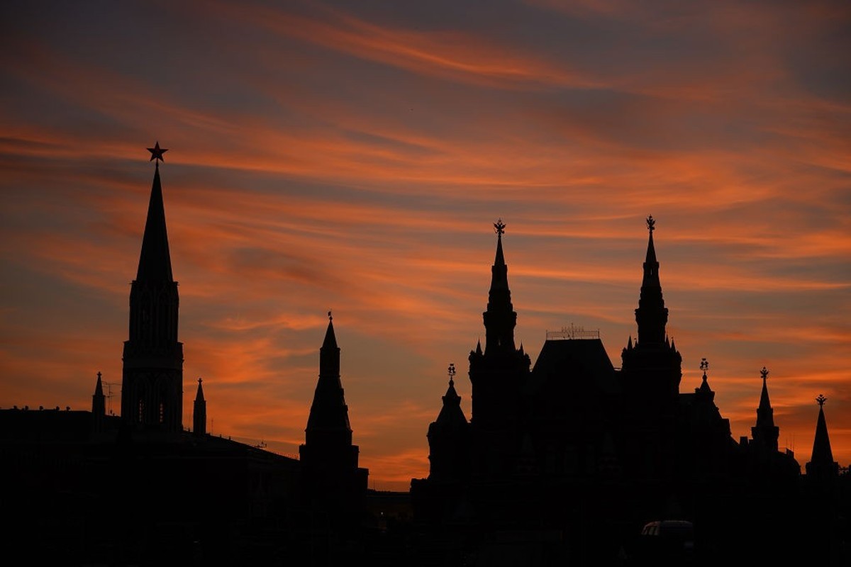 Silhouette of towers against a vibrant orange sunset sky.
