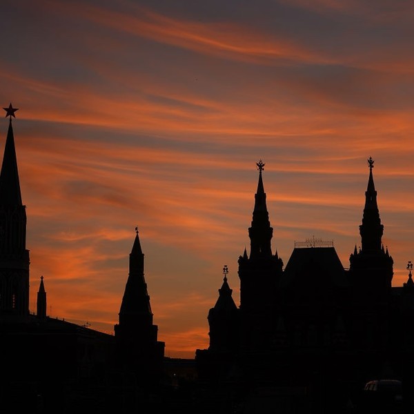 Silhouette of towers against a vibrant orange sunset sky.