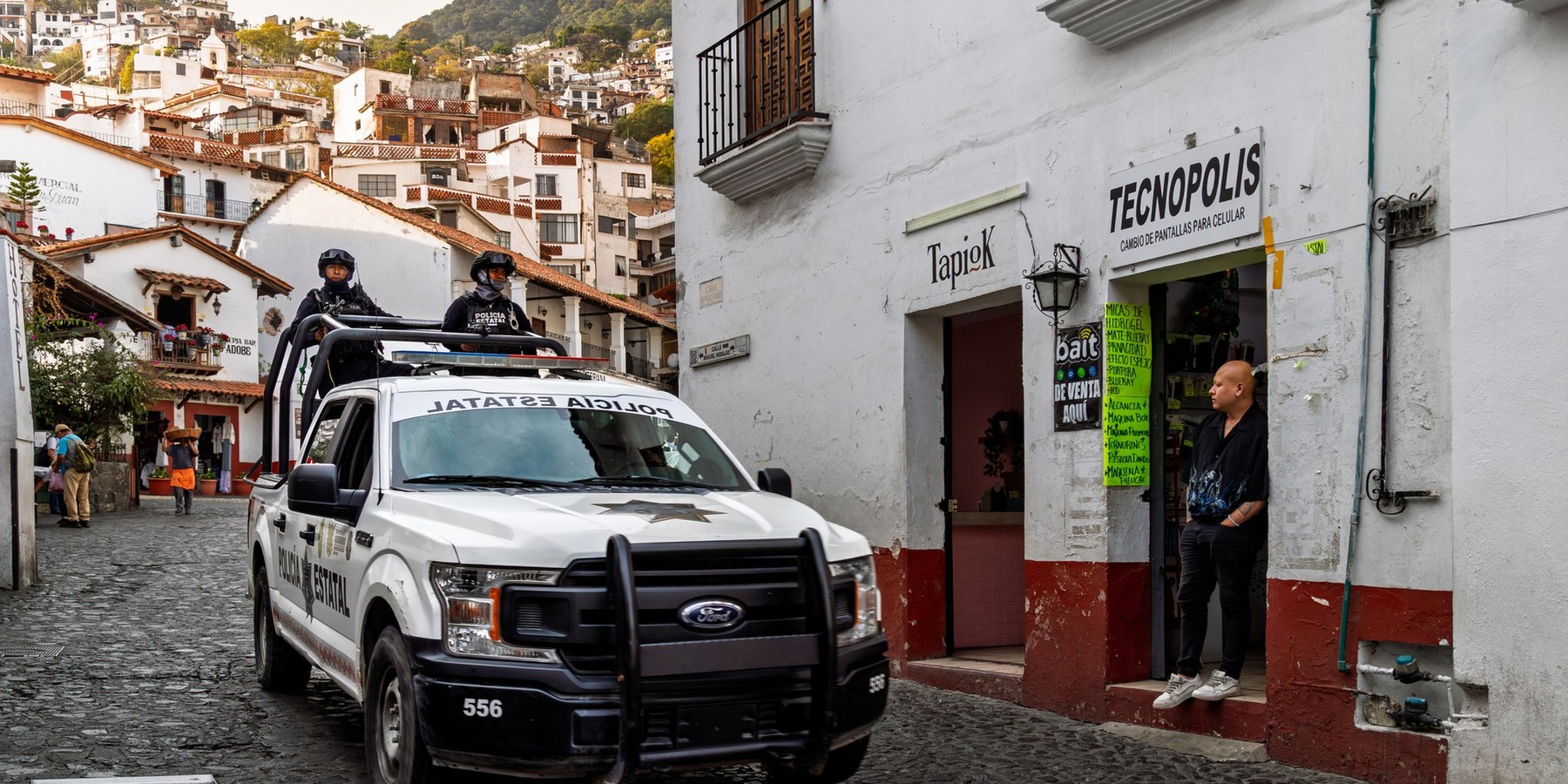 State police officers patrol cobblestone street in armored truck amid security concerns related to drug trafficking and violence in Guerrero - stock photo Taxco, Mexico - January 16, 2025: State police officers patrol cobblestone street in armored truck amid security concerns related to drug trafficking and violence in Guerrero