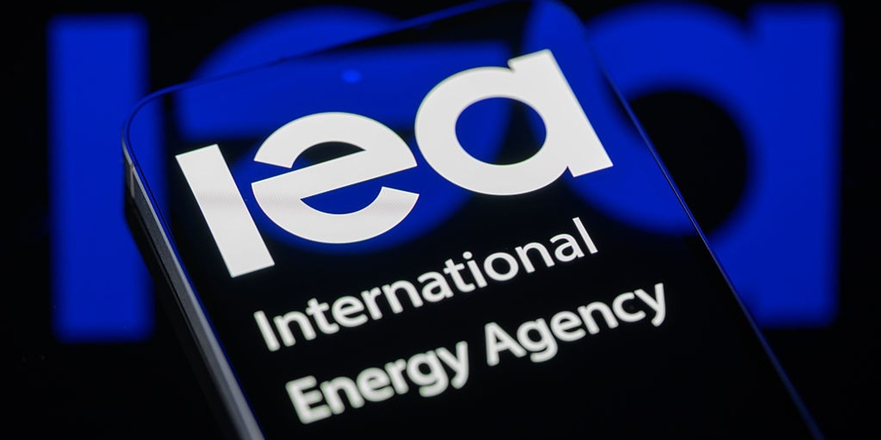 The International Energy Agency (IEA) logo is displayed on a smartphone screen in this photo illustration, as the global energy watchdog coordinates an emergency release of strategic oil reserves after the conflict involving Iran disrupts supplies and drives crude prices sharply higher. This photo is taken in Brussels, Belgium, on March 12, 2026. (Photo by Jonathan Raa/NurPhoto via Getty Images)