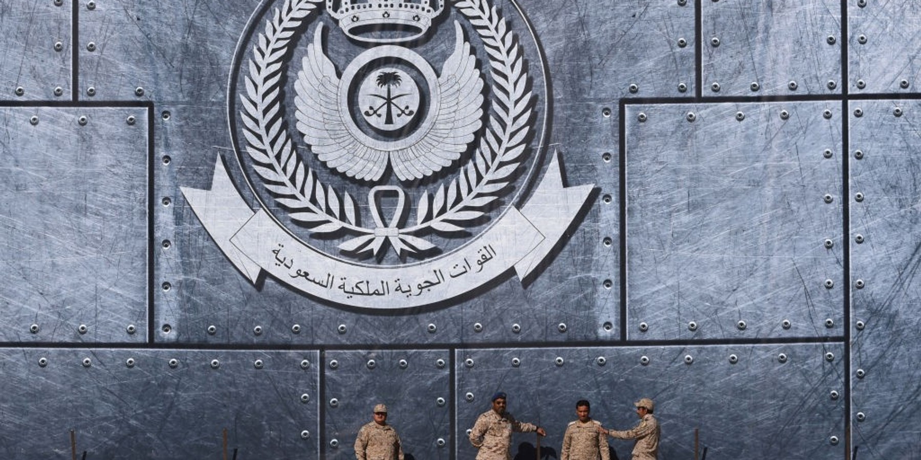 TOPSHOT - Army officers stand under the Saudi Air Force logo during a ceremony marking the 50th anniversary of the creation of the King Faisal Air Academy at King Salman airbase in Riyadh on January 25, 2017. (Photo by FAYEZ NURELDINE / AFP) (Photo by FAYEZ NURELDINE/AFP via Getty Images)