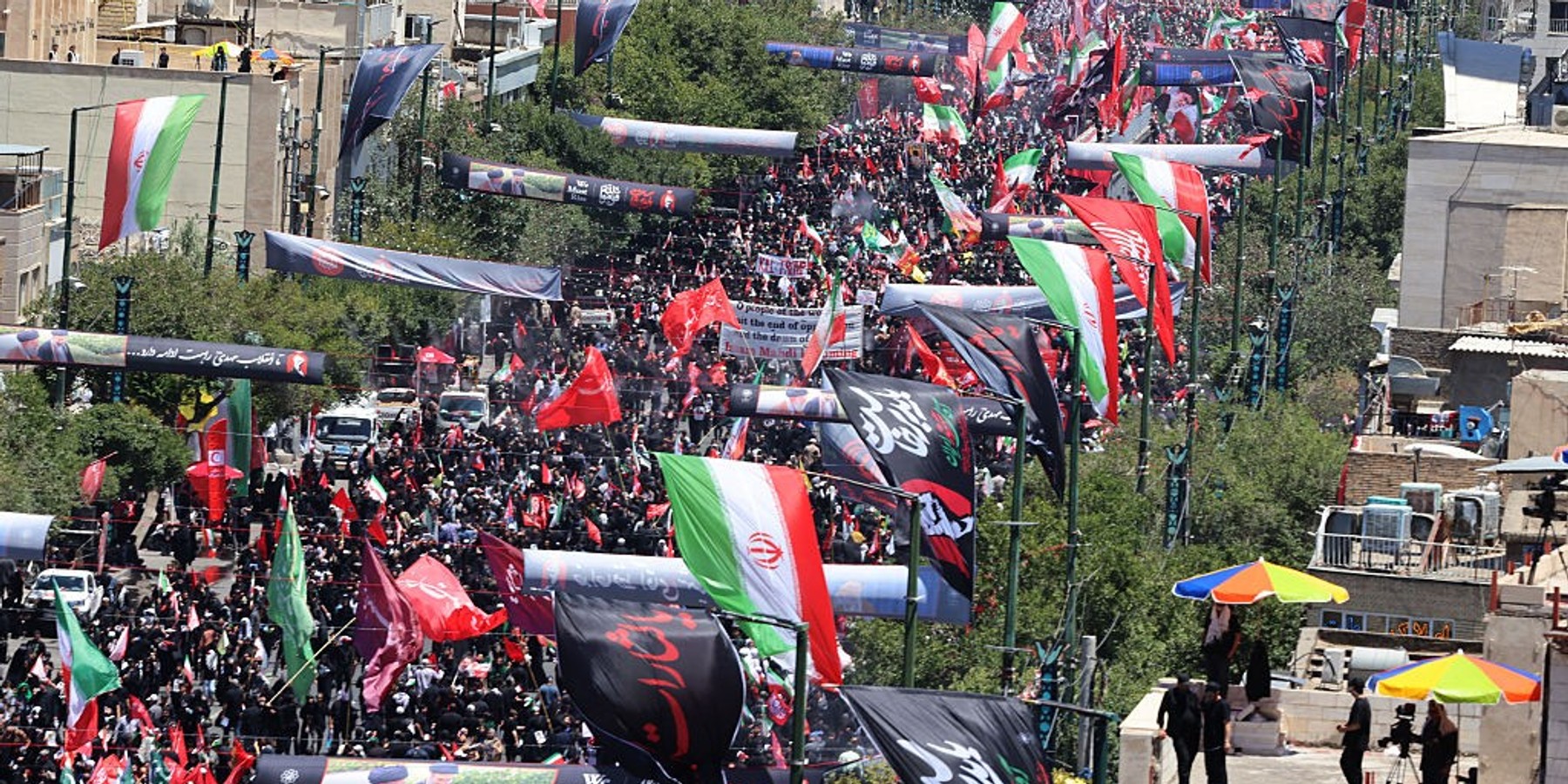 TOPSHOT-IRAN-US-ISRAEL-WAR-FUNERAL TOPSHOT - Mourners gather in the street ahead of the funeral of Iran's slain supreme leader Ali Khamenei and members of his family at the Shrine of Imam Reza, Iran's most revered place of worship, in Mashhad on July 9, 2026. A plane carrying the coffin of late Iranian supreme leader Ali Khamenei landed in the eastern holy city of Mashhad on July 9, ahead of his burial, state media reported. (Photo by ATTA KENARE / AFP via Getty Images) /