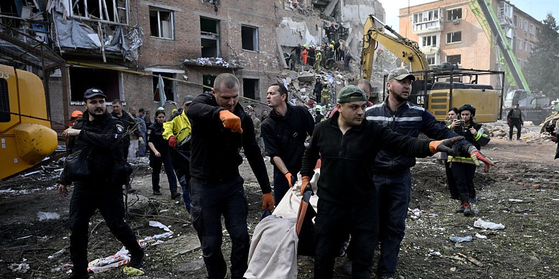 TOPSHOT-UKRAINE-RUSSIA-CONFLICT-WAR TOPSHOT - Rescuers carry a body of a local resident as they conduct search and rescue operations at the site of a Russian aerial strike at a multi-floor residential building in Pryluky on October 7, 2026, amid Russian invasion of Ukraine. In Pryluky, the death toll has risen to nine people, including three children, and 40 people are known to have been injured, including seven children, the Emergency Service said on October 7, 2026. (Photo by Genya Savilov / AFP via Getty Images)