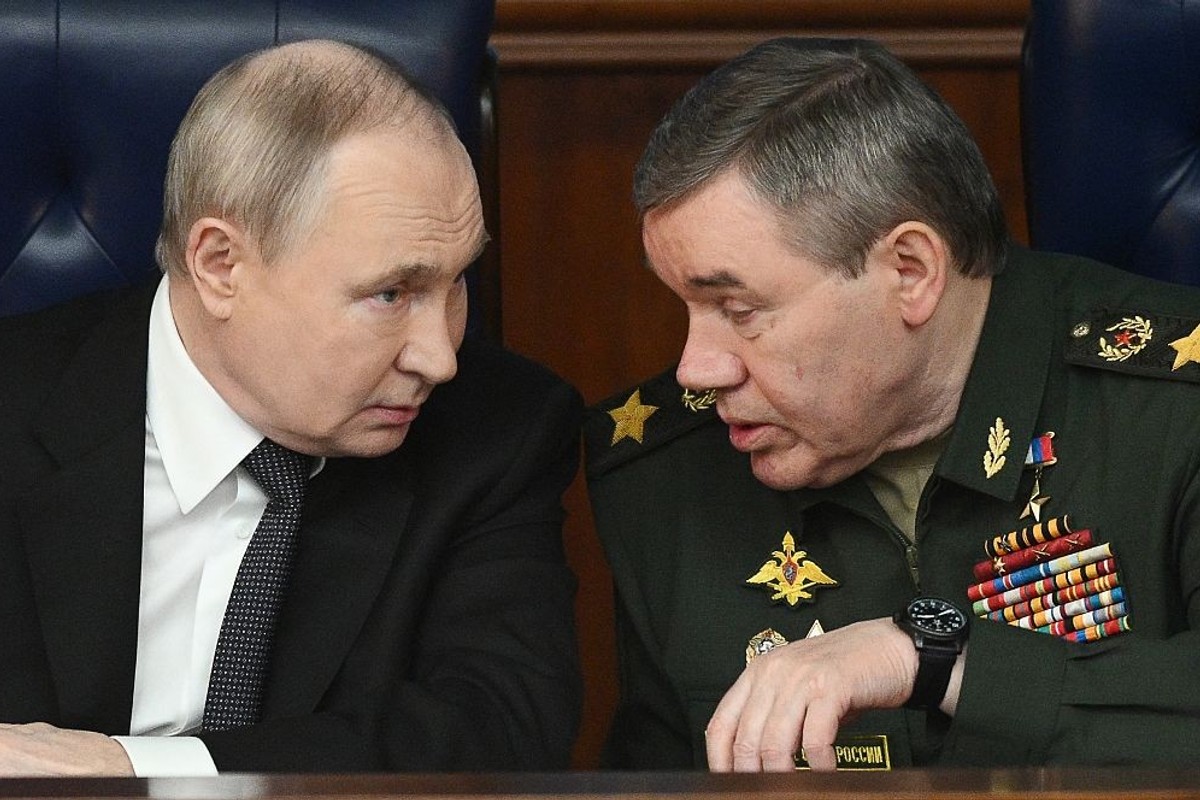 Two men in a serious conversation, one in a suit, the other in a military uniform.