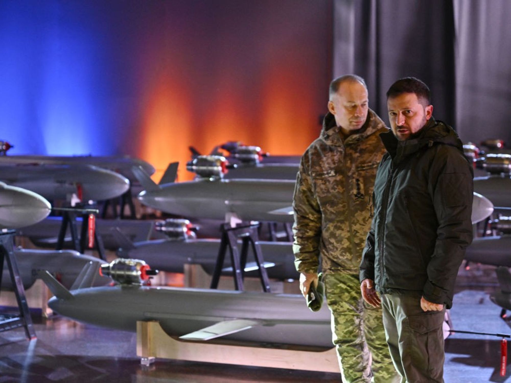 Ukrainian President Volodymyr Zelensky (R) and Commander-in-Chief of the Armed Forces of Ukraine Oleksandr Syrsky (L) speak next to the first batch of Ukrainian made drone missiles "Peklo" (Hell) delivered to the Defence Forces of Ukraine in Kyiv on December 6, 2024, amid the Russian invasion of Ukraine.