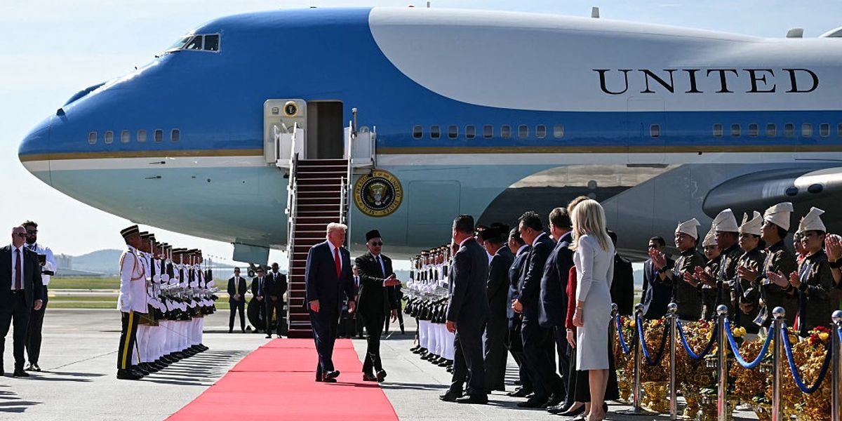 US President Donald Trump (centre L) walks with Malaysia's Prime Minister Anwar Ibrahim (centre R) next to Air Force One upon arrival at Kuala Lumpur International Airport in Sepang on October 26, 2025