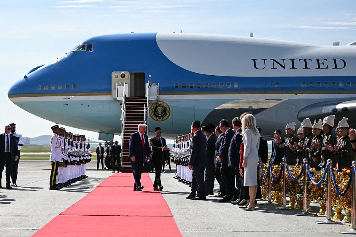 US President Donald Trump (centre L) walks with Malaysia's Prime Minister Anwar Ibrahim (centre R) next to Air Force One upon arrival at Kuala Lumpur International Airport in Sepang on October 26, 2025